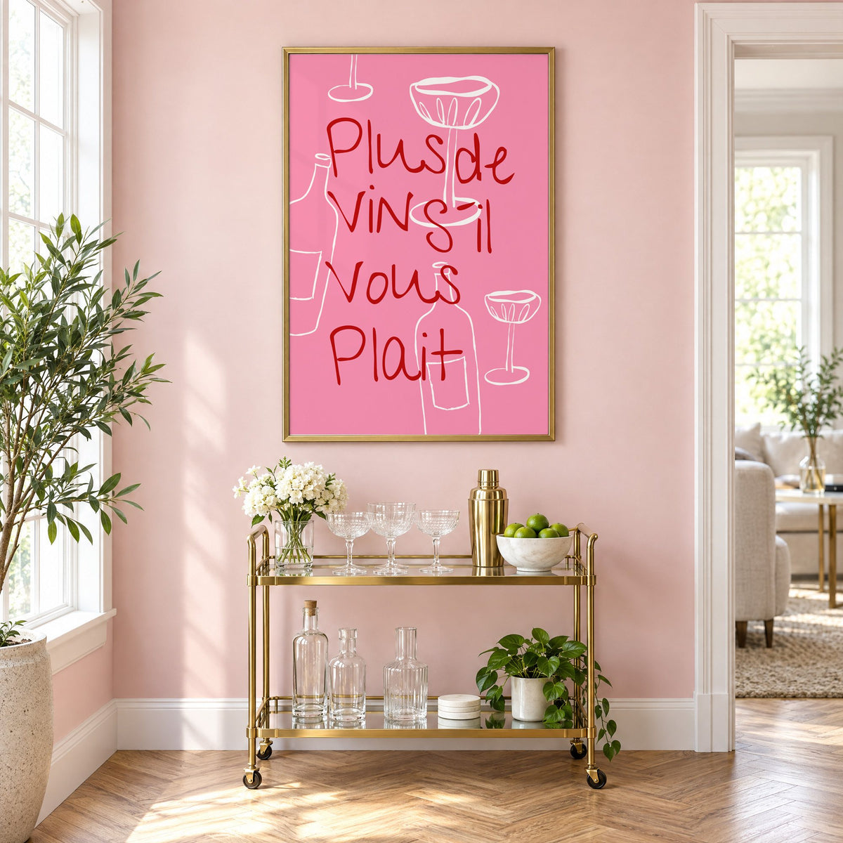 Plus de Vin handwritten pink print in a brass frame above a gold bar cart on a blush pink wall