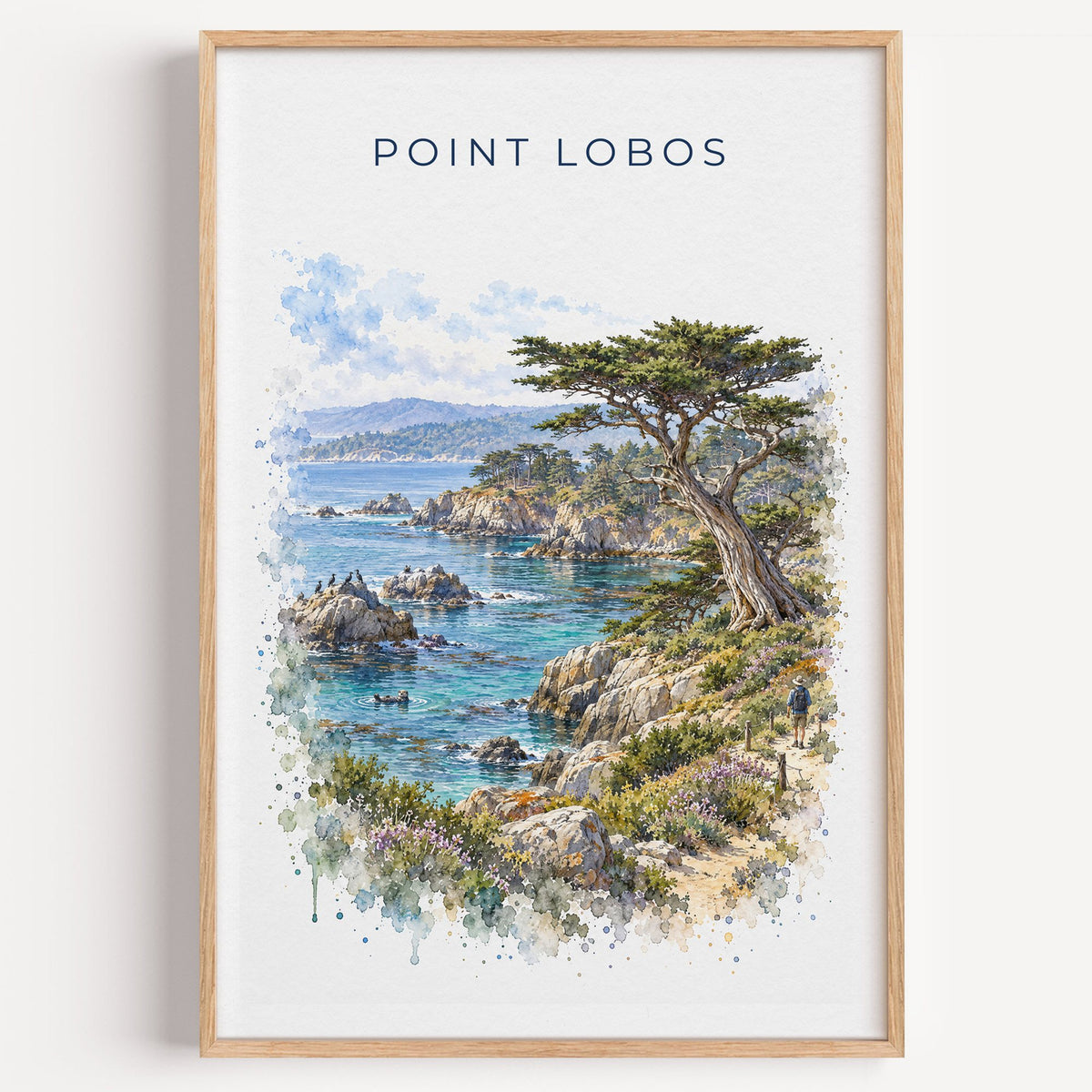 Point Lobos State Natural Reserve watercolor print in a light oak frame on a plain white wall
