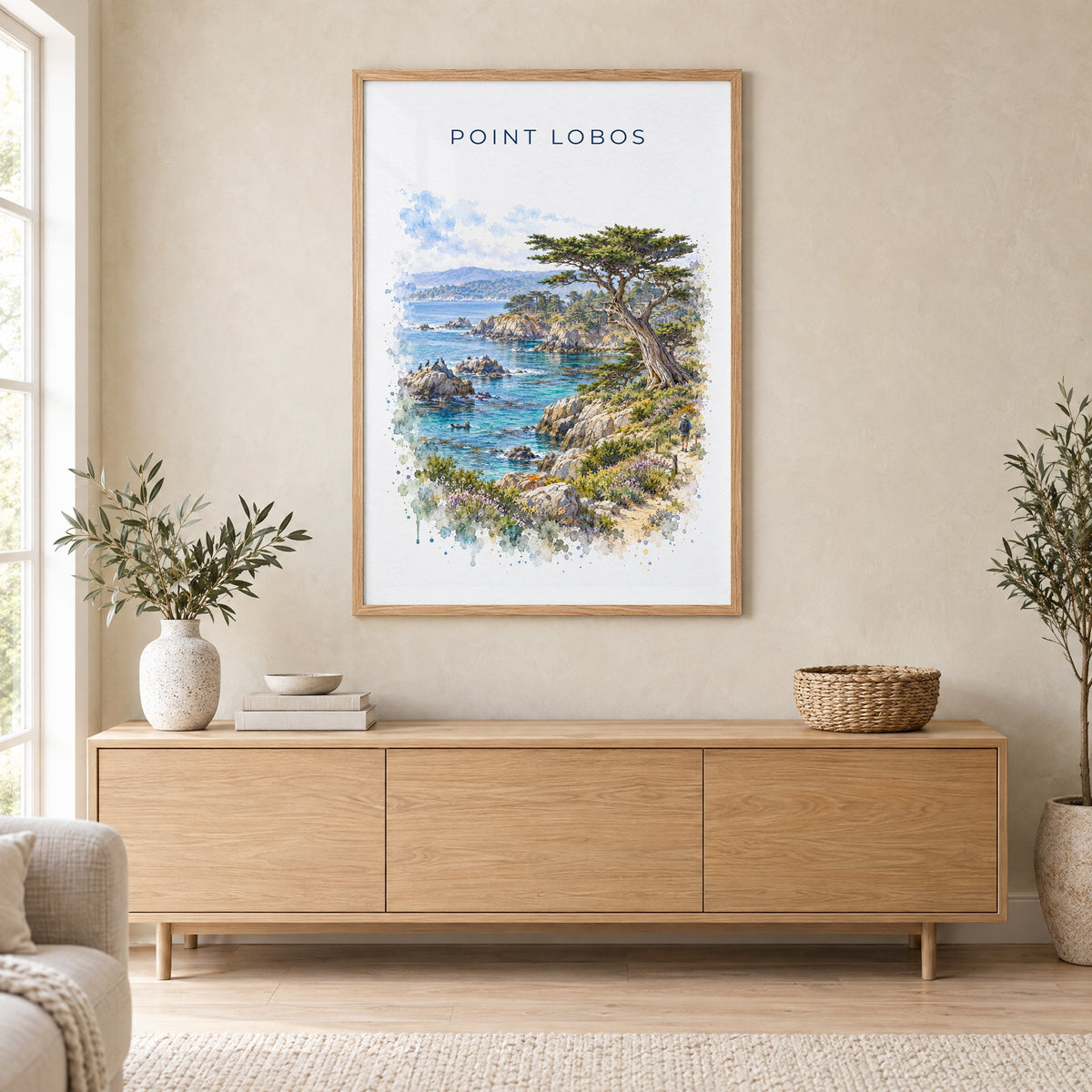 Point Lobos State Natural Reserve watercolor print in an oak frame above a light wood sideboard in a Scandinavian living room