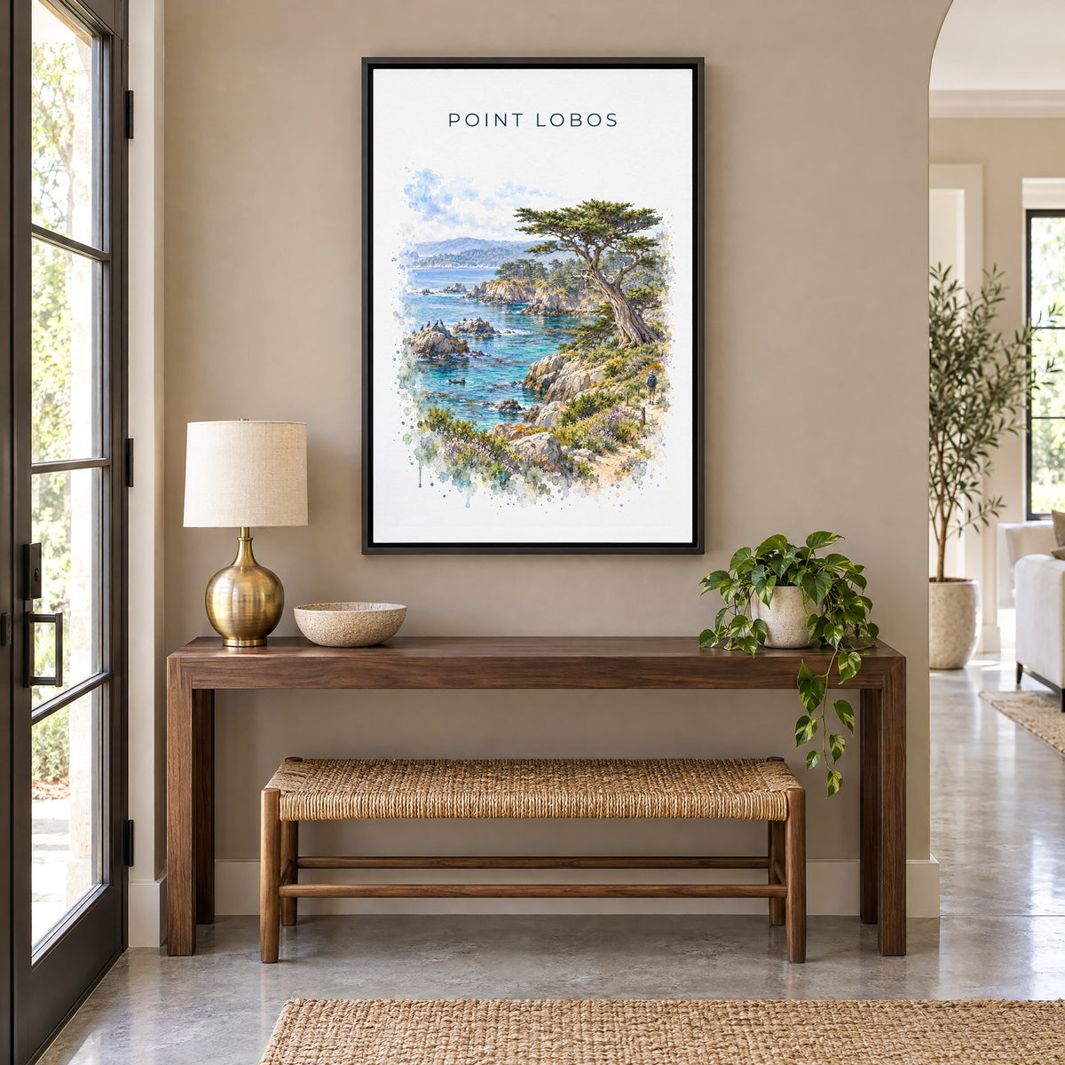 Point Lobos State Natural Reserve watercolor as a black floater canvas above a walnut console and woven bench in an entryway