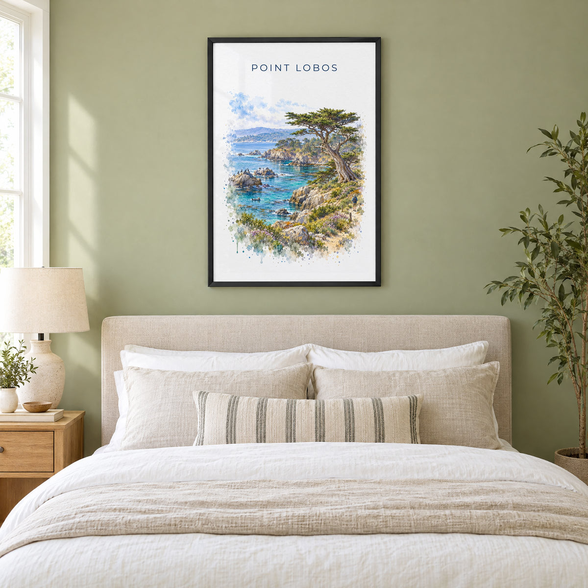 Point Lobos State Natural Reserve watercolor print in a black frame above an upholstered headboard in a sage green bedroom