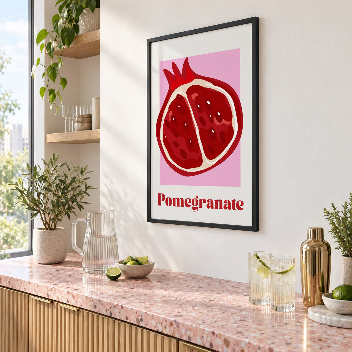 Pomegranate half bold serif pink panel print in a black frame above a pink terrazzo cocktail counter with limes, seen at an angle