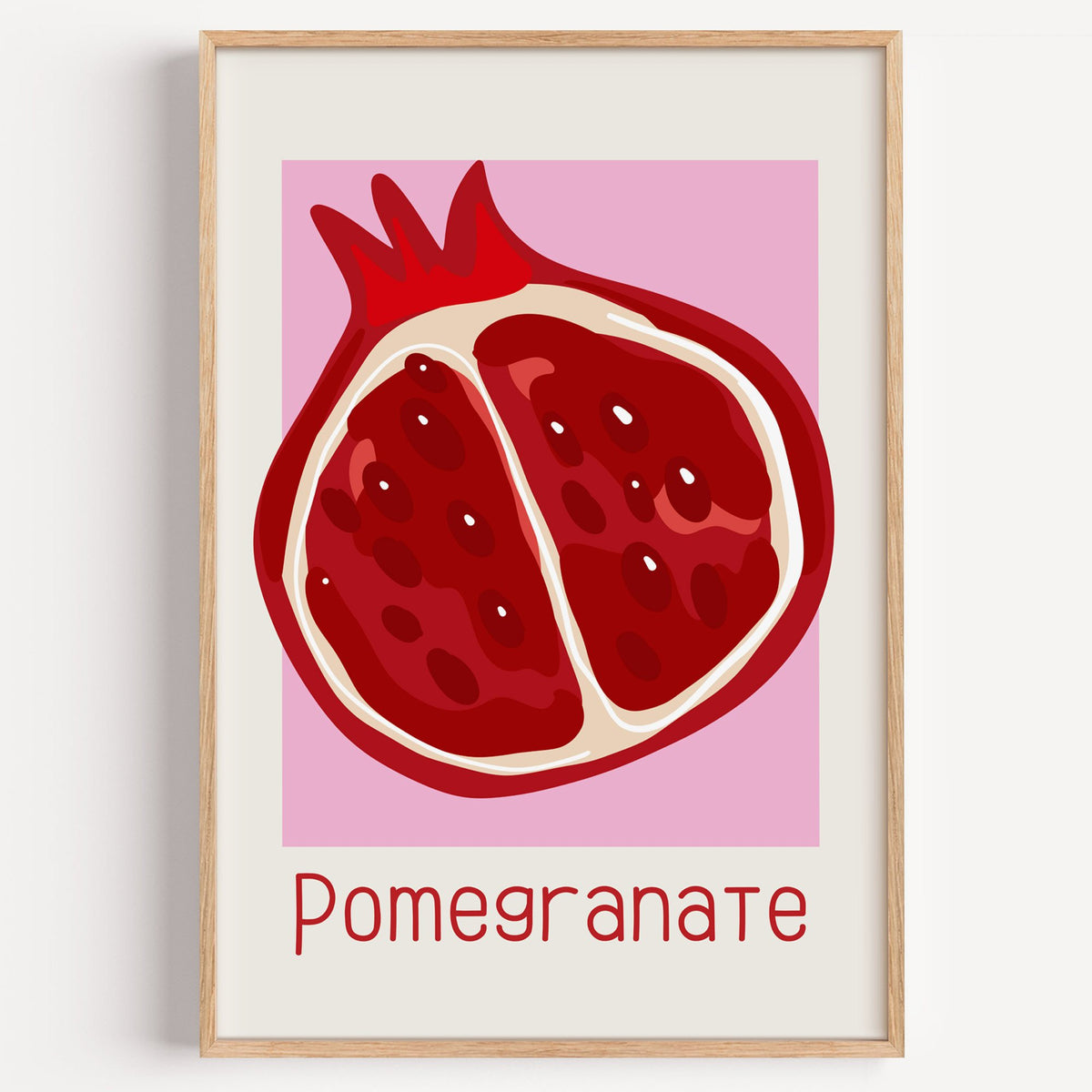 Pomegranate thin lettering halved fruit print in a light oak frame on a plain white wall