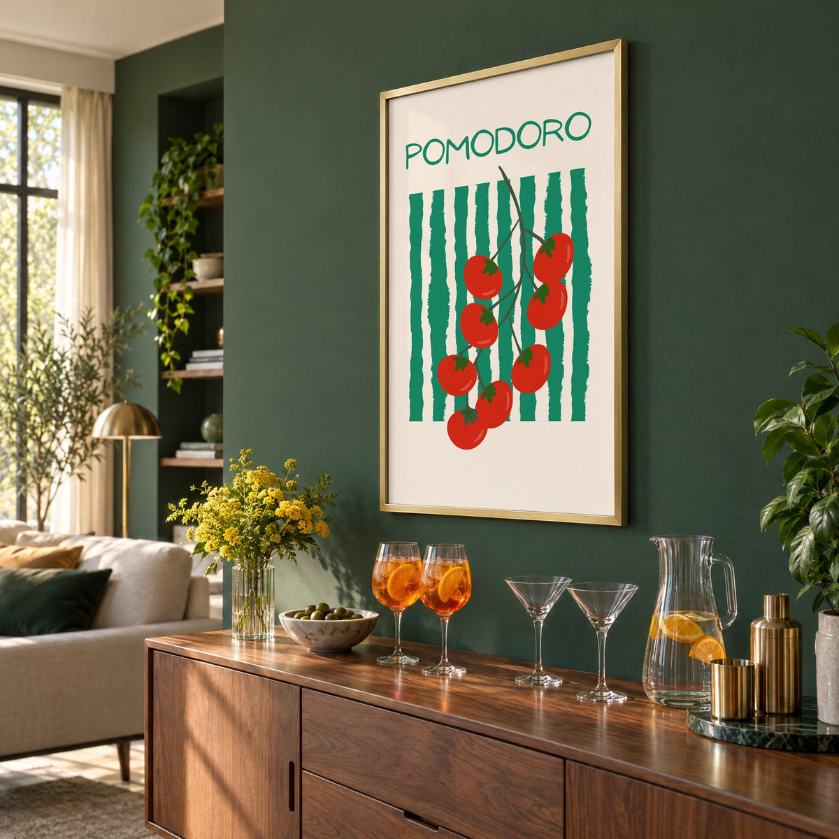 POMODORO cherry tomato vine striped print in a brass frame on a bottle green wall above a sideboard with spritz and martini glasses, seen at an angle