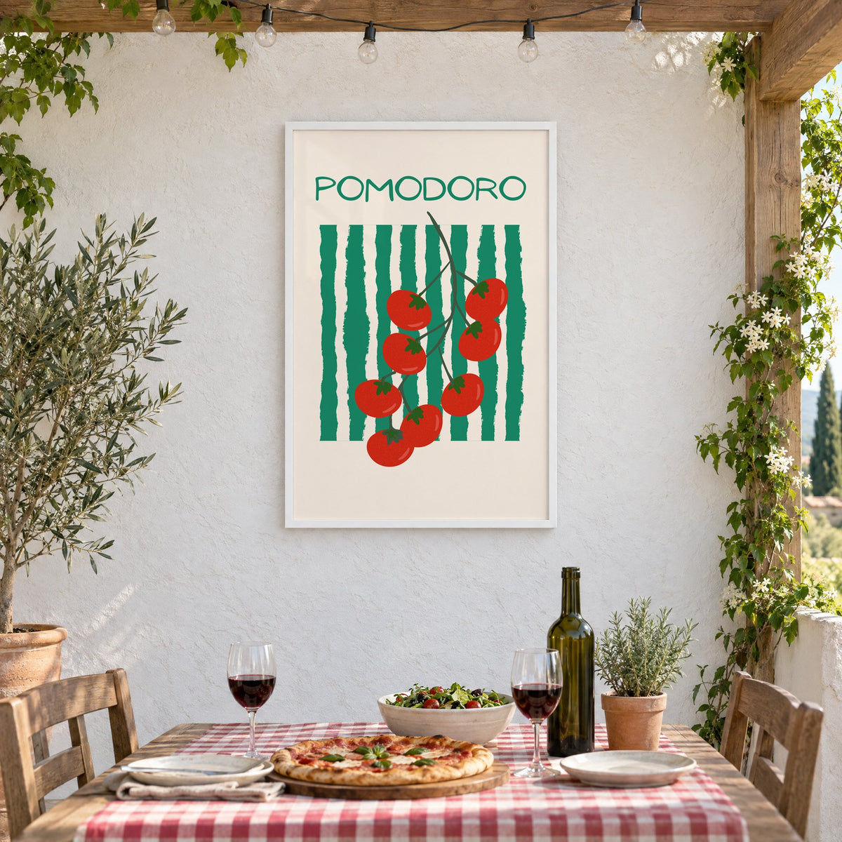 POMODORO cherry tomato vine striped print in a white frame on a stucco wall above a checked-cloth table with pizza and red wine