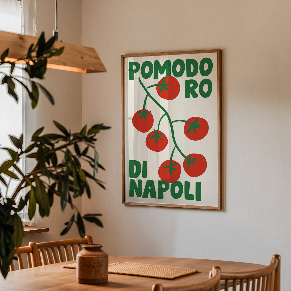 Pomodoro di Napoli tomato print in a walnut frame above a table beside an olive tree