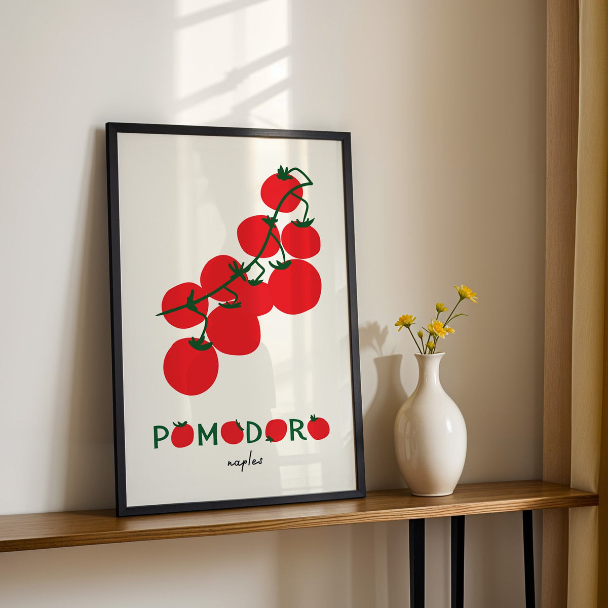 Pomodoro Naples tomato vine print in a black frame on a console table with daisies