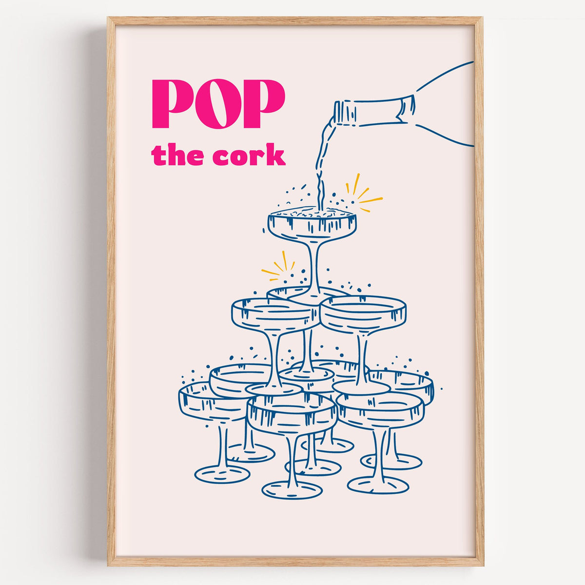 Pop the cork champagne tower print in a light oak frame on a plain white wall