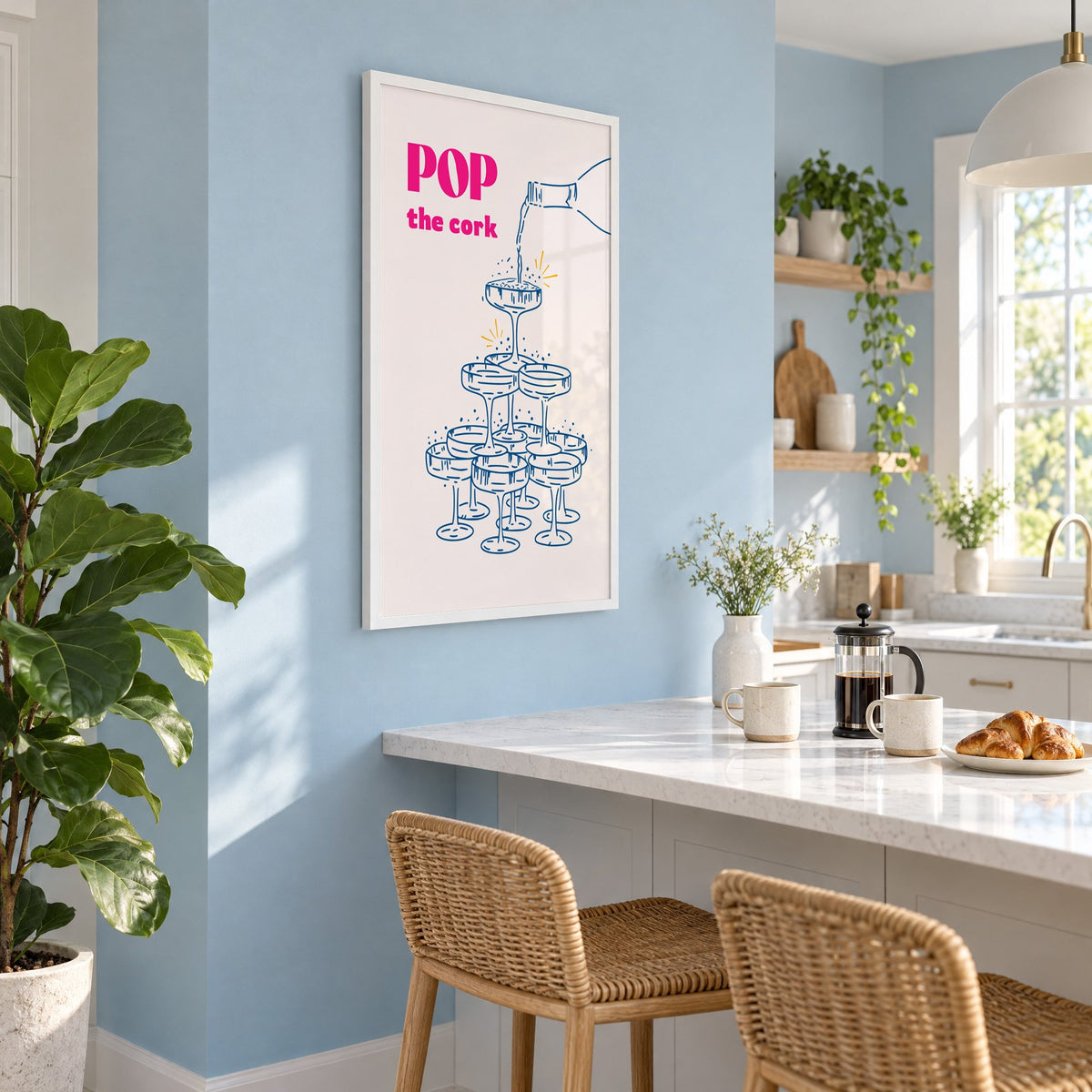 Pop the cork champagne tower print in a white frame on a pale blue wall above a breakfast bar with rattan stools