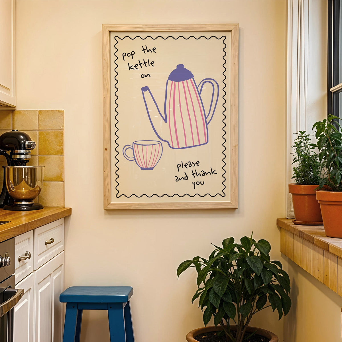 Pop the kettle on teapot print in a wood frame on a yellow tiled kitchen wall