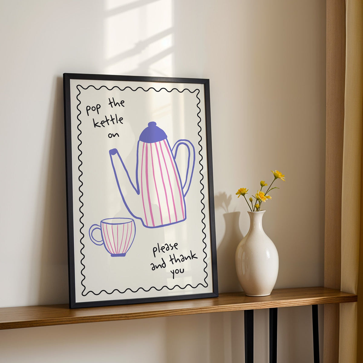 Pop the kettle on teapot print in a black frame on a console table with daisies