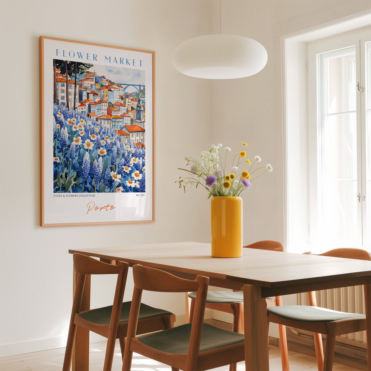 Porto flower market print in an oak frame above a dining table with a yellow vase and white pendant light