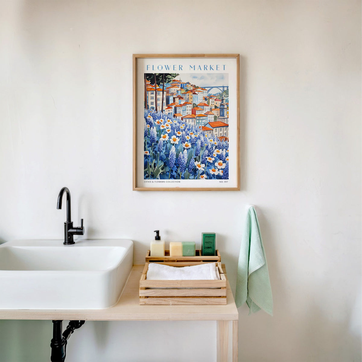 Porto flower market print in an oak frame above a white bathroom sink with folded towels