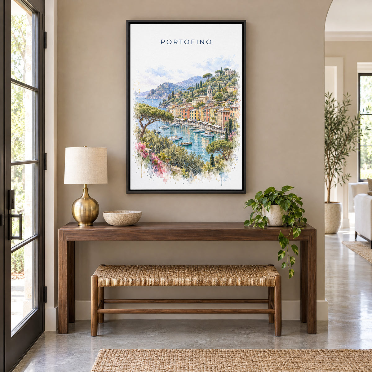 Portofino watercolor print as a black floater canvas above a walnut console and woven bench in an entryway