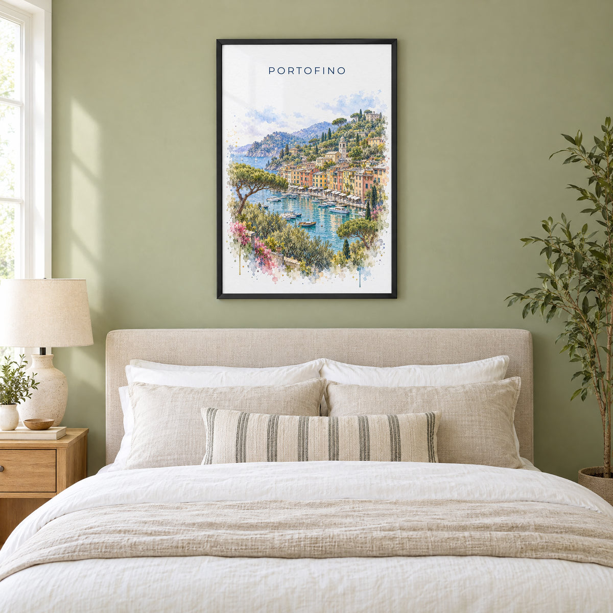 Portofino watercolor print in a black frame above an upholstered headboard in a sage green bedroom