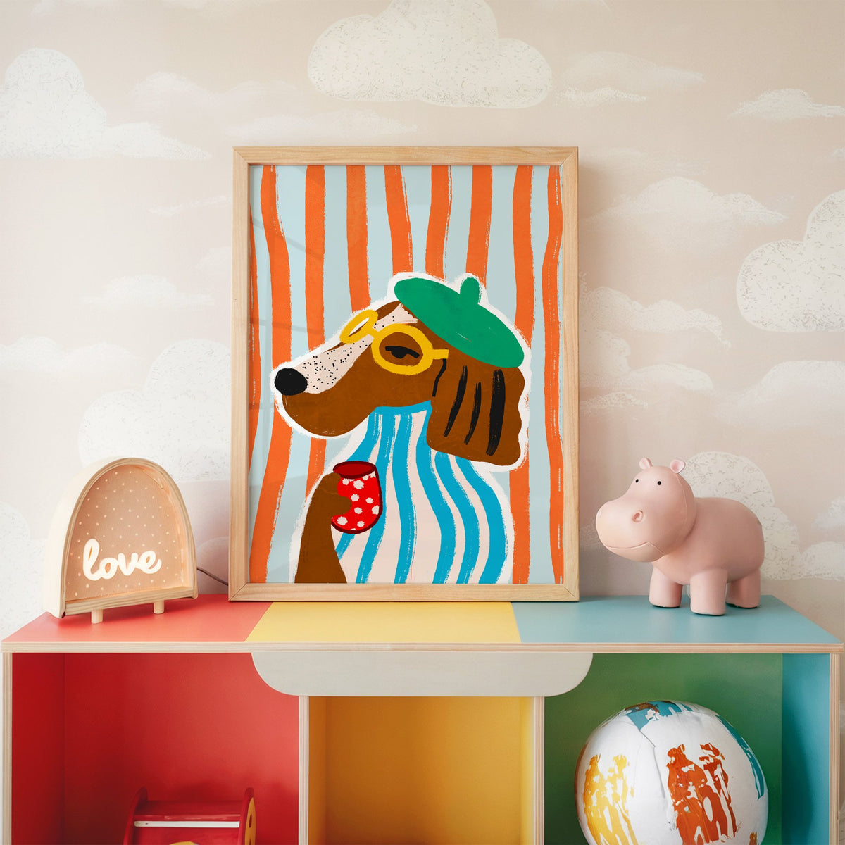 Posh dog in green beret nursery print in an oak frame on a rainbow toy shelf against cloud wallpaper