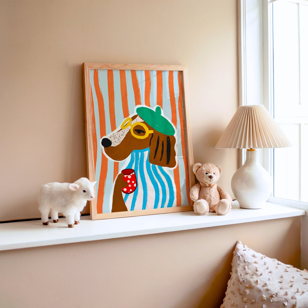 Posh dog in green beret nursery print in an oak frame on a window ledge with a toy lamb and teddy