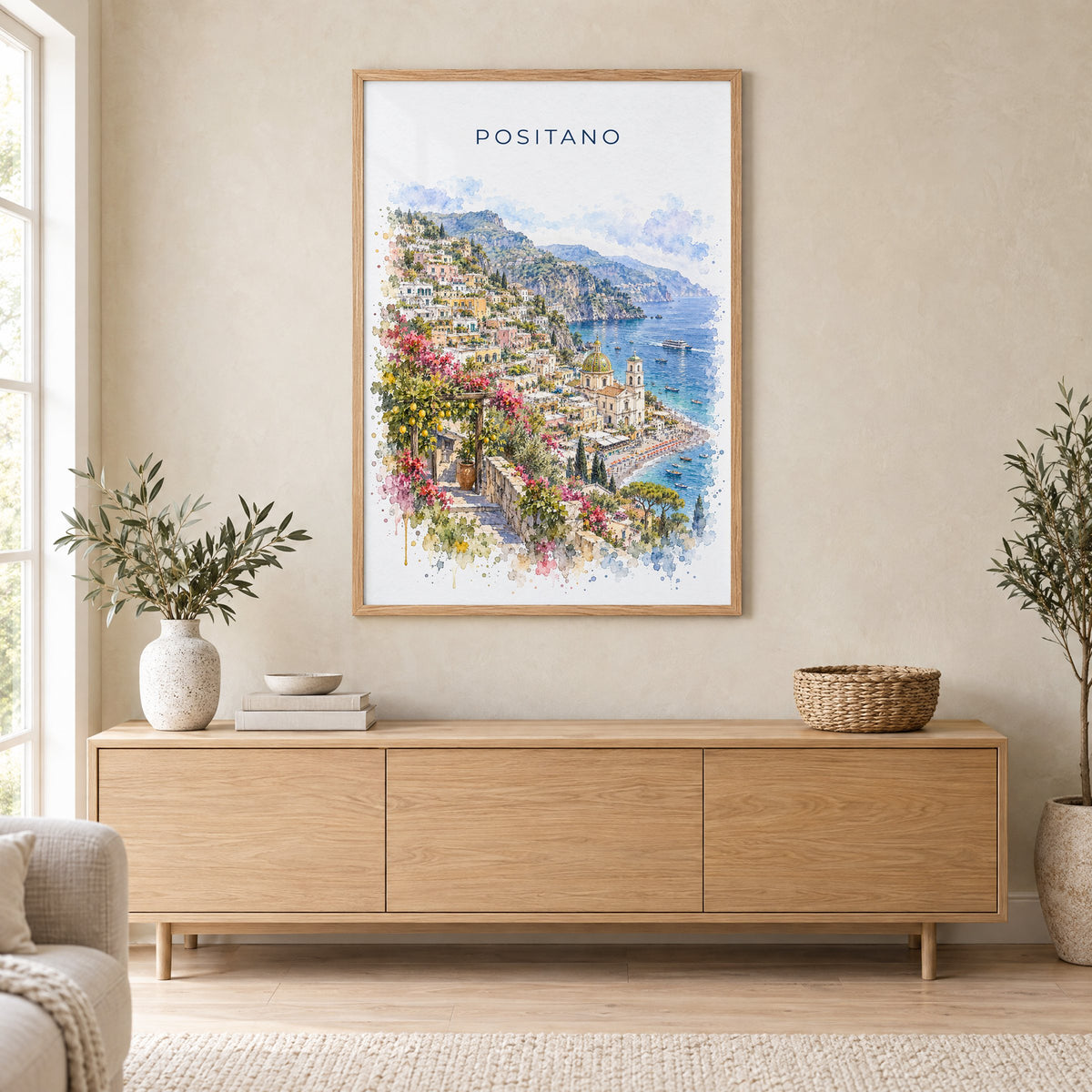 Positano watercolor print in an oak frame above a light wood sideboard in a Scandinavian living room