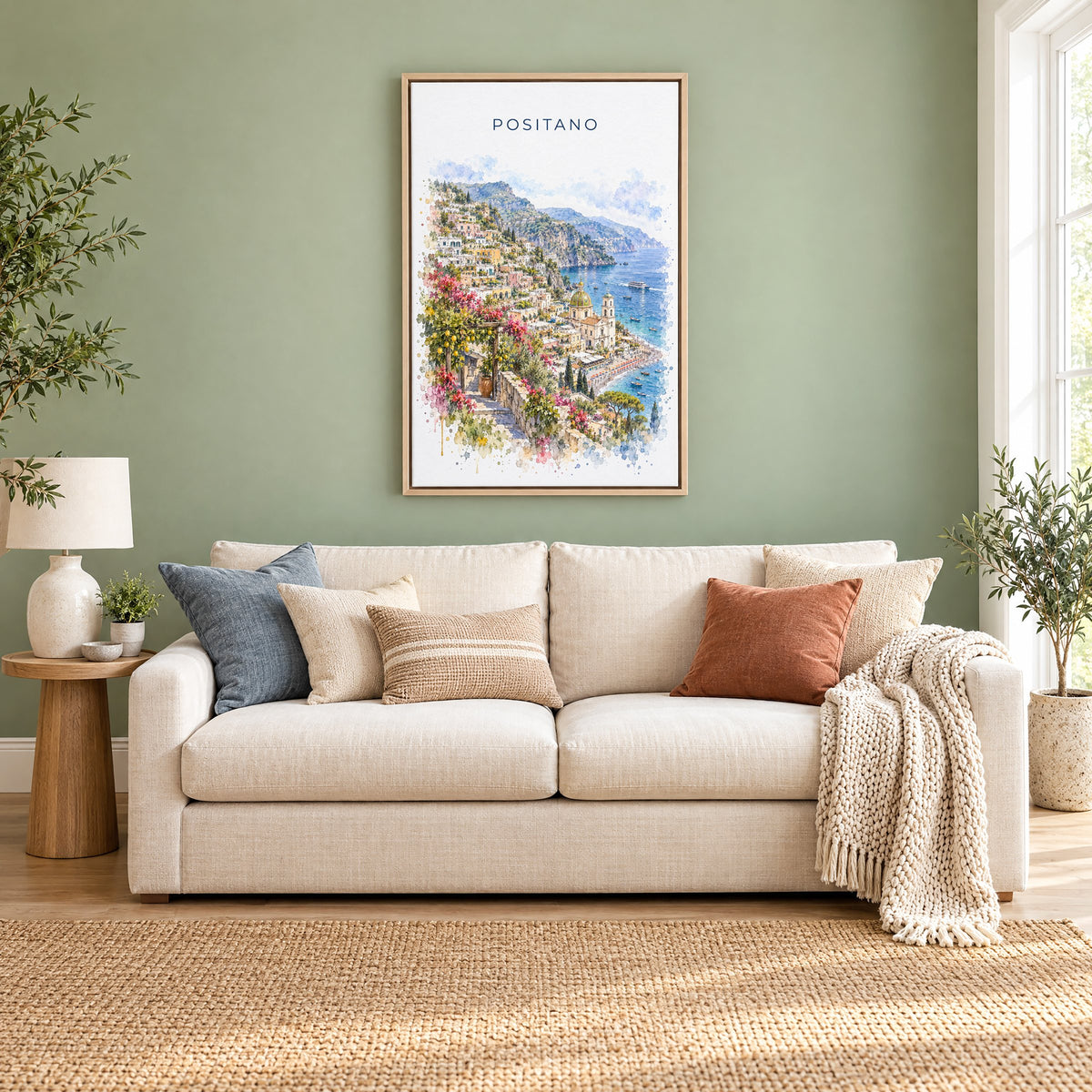 Positano watercolor print as a natural floater canvas above a cream linen sofa on a sage green wall