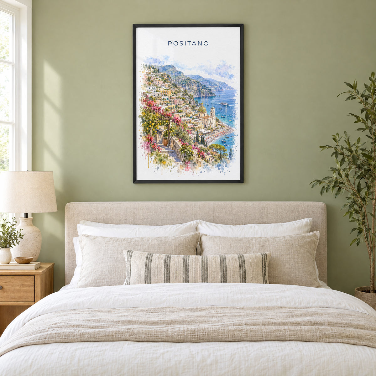 Positano watercolor print in a black frame above an upholstered headboard in a sage green bedroom