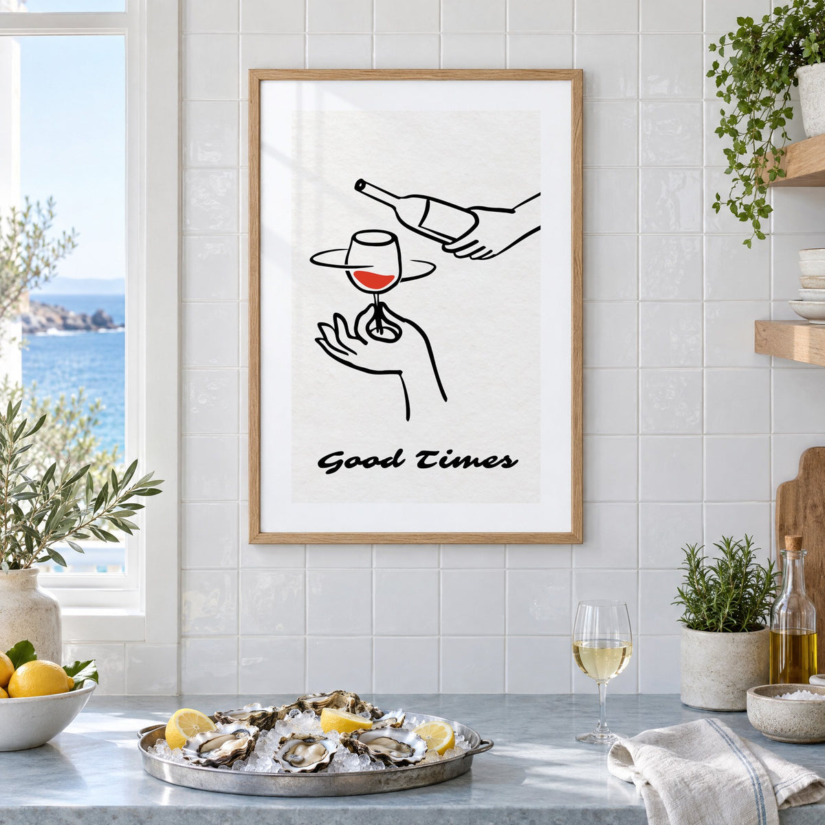 Good Times wine bottle and glass line print in an oak frame on white tiles above a marble counter with oysters and lemons by a sea view
