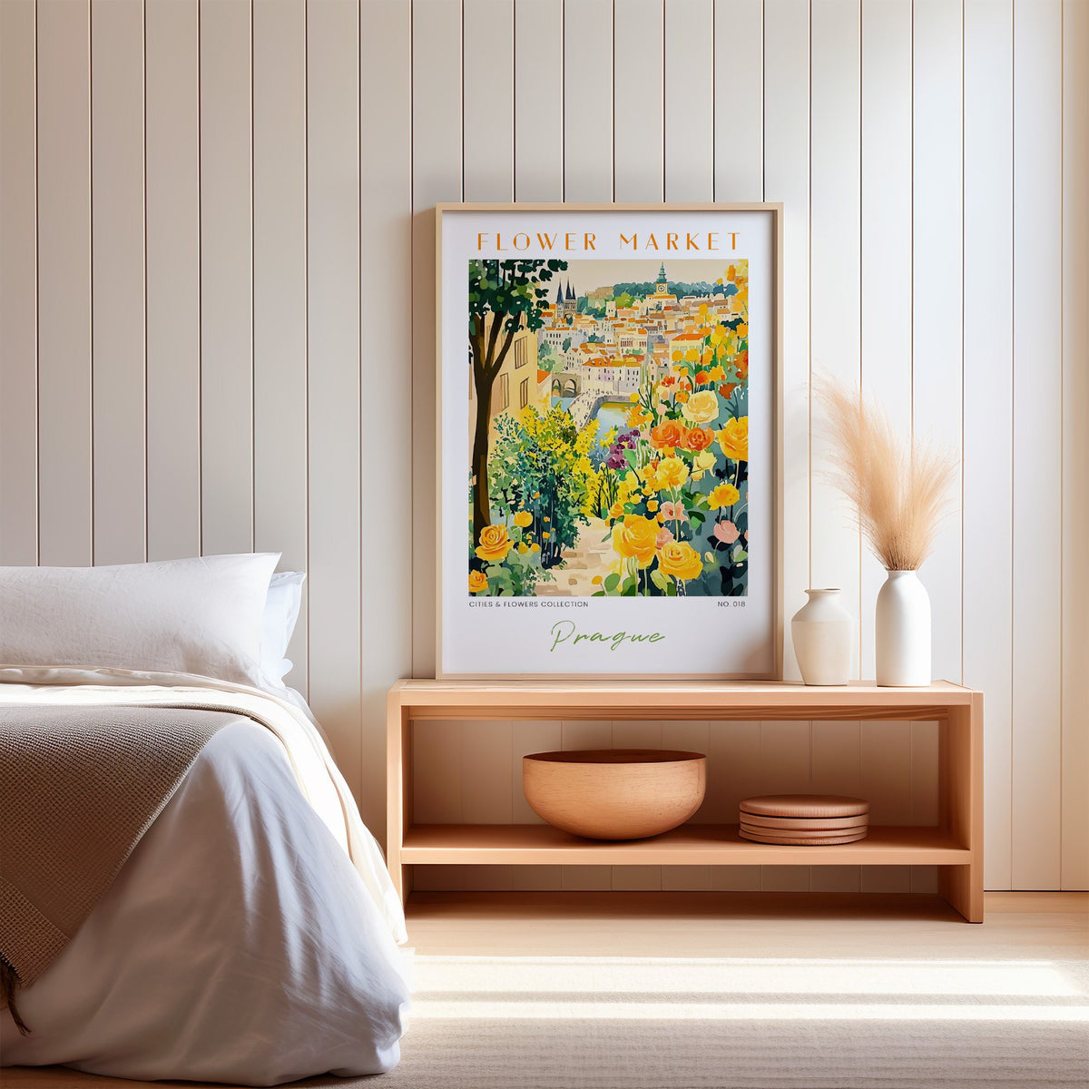 Prague flower market print in an oak frame on a wood bench against a white shiplap bedroom wall with pampas grass