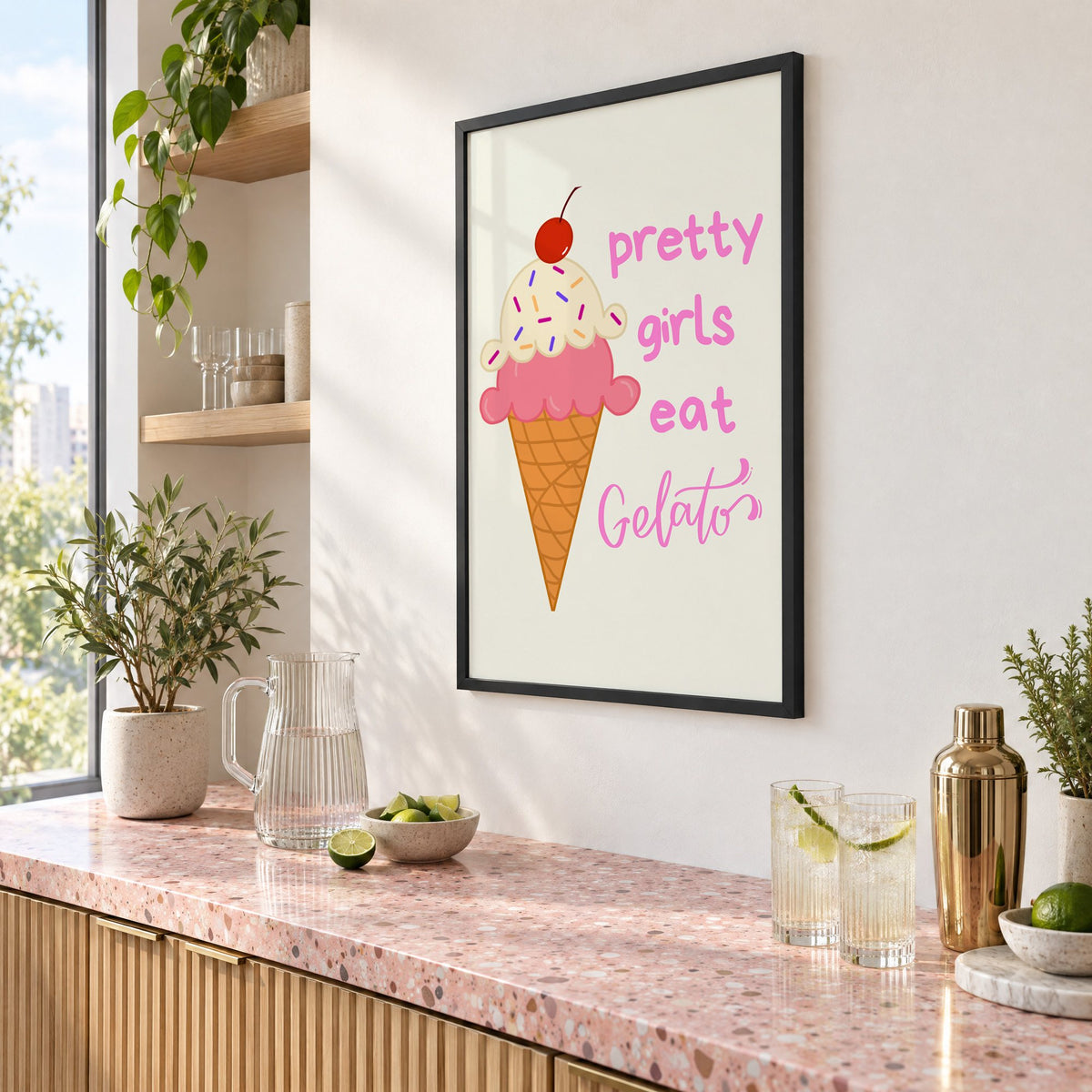Pretty girls eat Gelato cone print in a black frame above a pink terrazzo cocktail counter with limes, seen at an angle