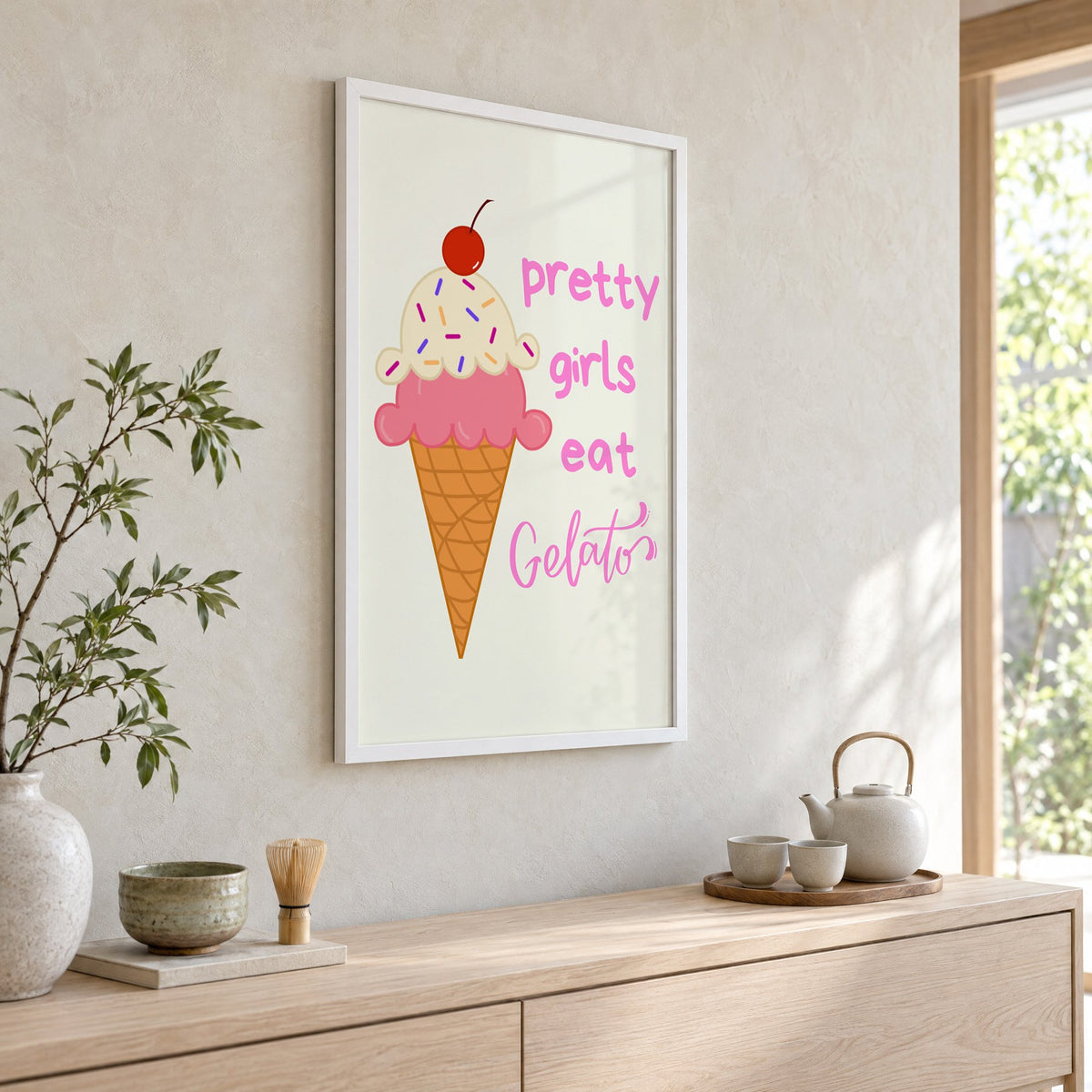 Pretty girls eat Gelato cone print in a white frame above a pale wood console with a matcha tea set