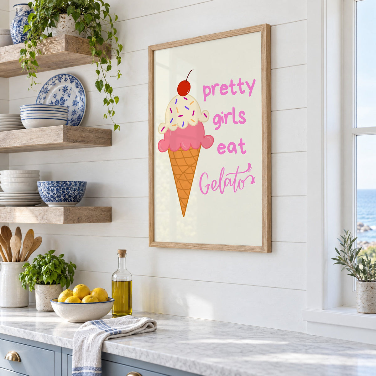 Pretty girls eat Gelato cone print in an oak frame in a white coastal kitchen beside blue and white plates