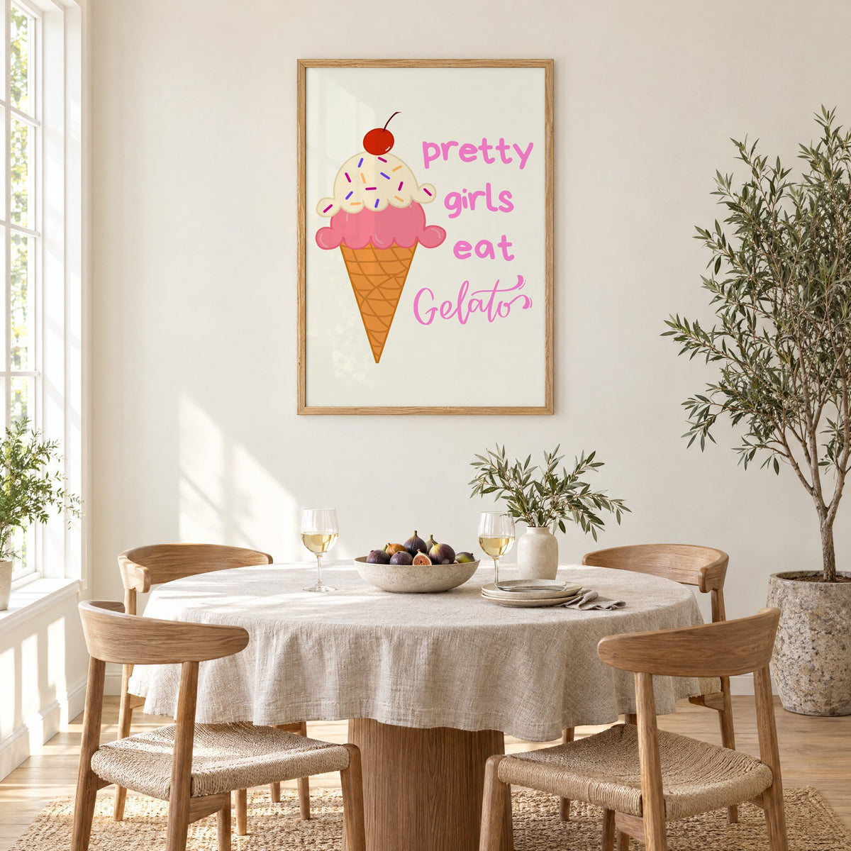 Pretty girls eat Gelato cone print in an oak frame above a round linen-covered dining table with figs and wine