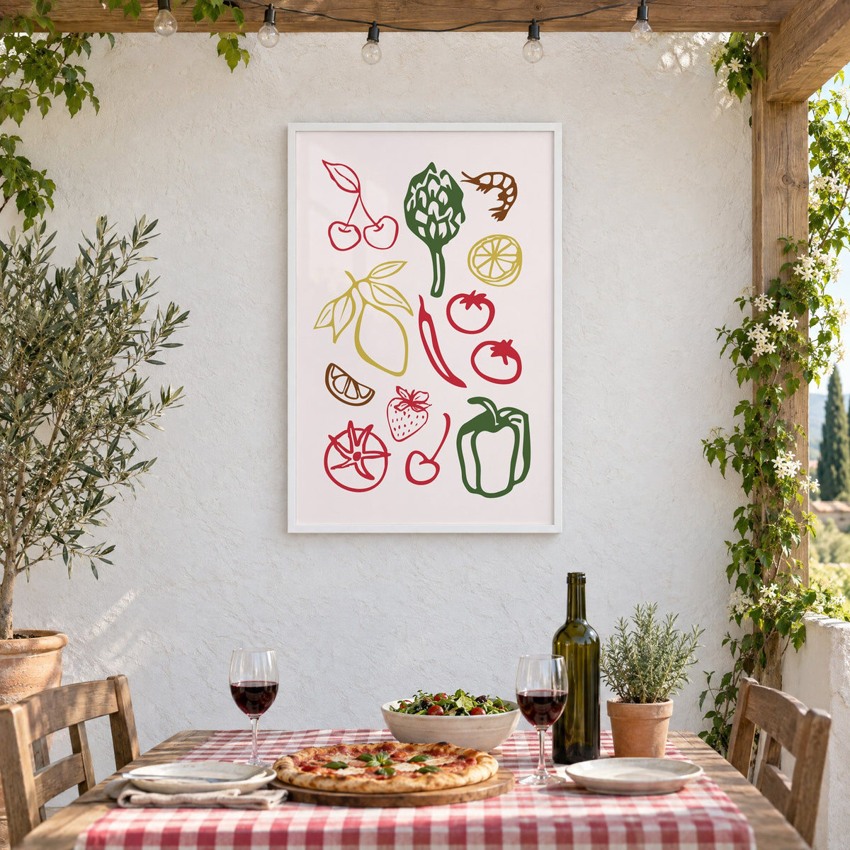 Multicolor produce doodle pattern print in a white frame on a stucco wall above a checked-cloth table with pizza and red wine