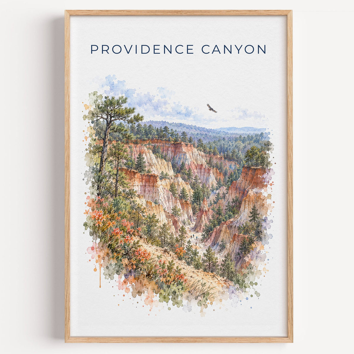 Providence Canyon State Park watercolor print in a light oak frame on a plain white wall