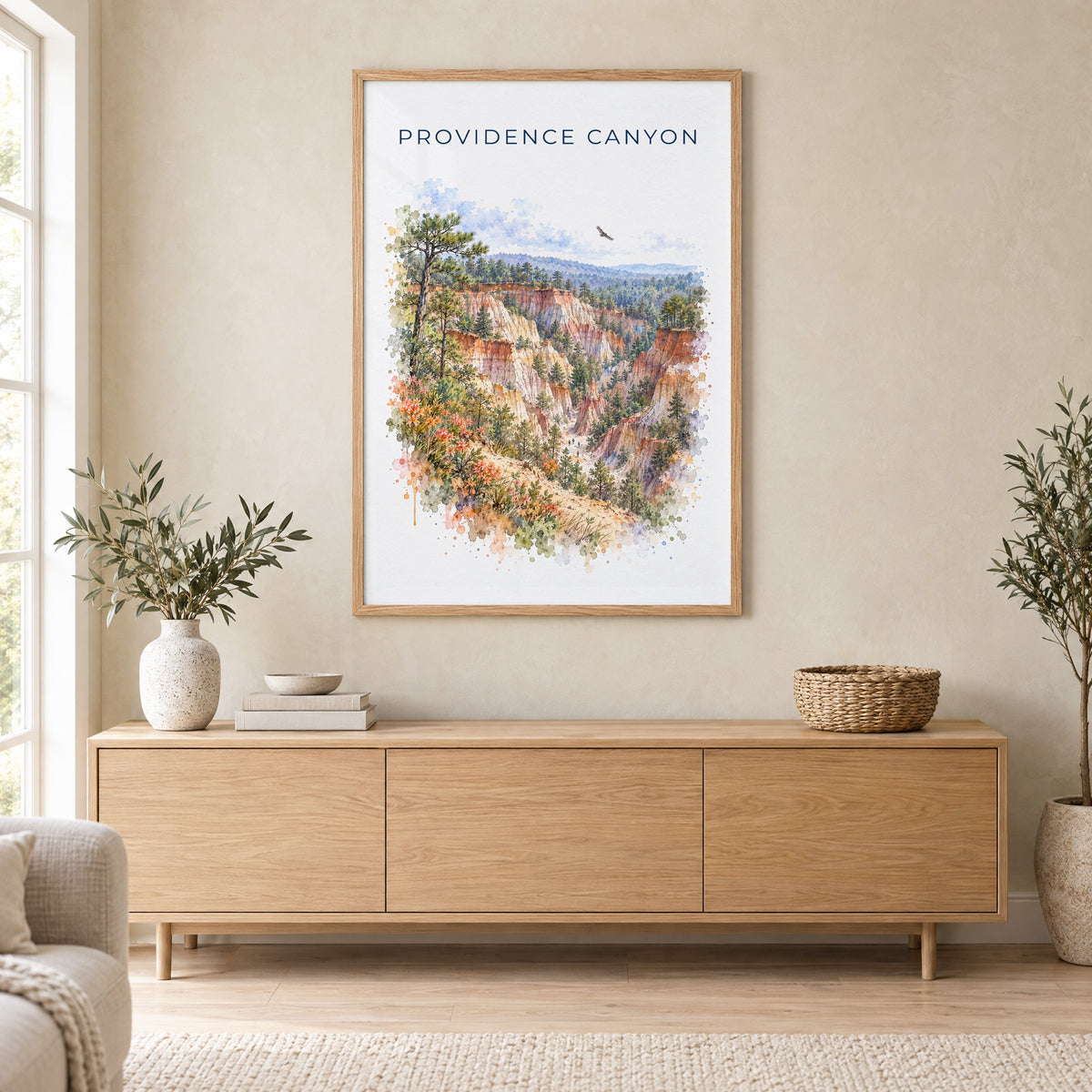 Providence Canyon State Park watercolor print in an oak frame above a light wood sideboard in a Scandinavian living room