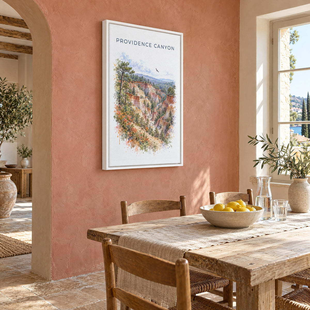 Providence Canyon State Park watercolor print as a white floater canvas on a terracotta wall above a rustic dining table