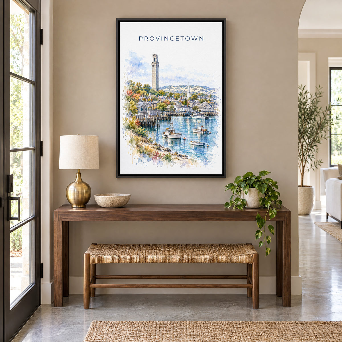Provincetown watercolor print as a black floater canvas above a walnut console and woven bench in an entryway