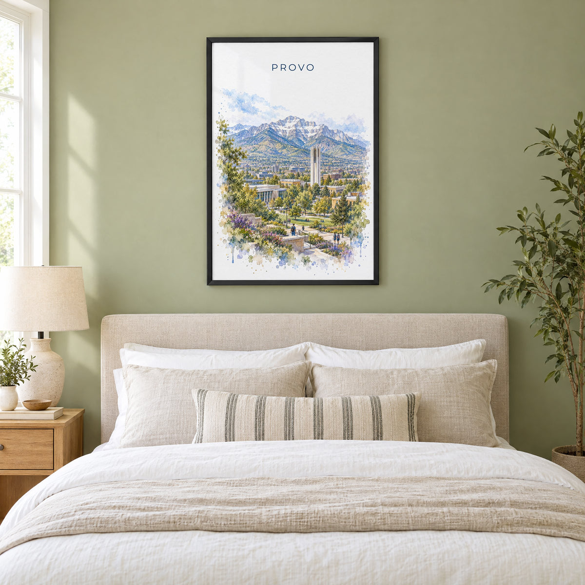 Provo watercolor print in a black frame above an upholstered headboard in a sage green bedroom