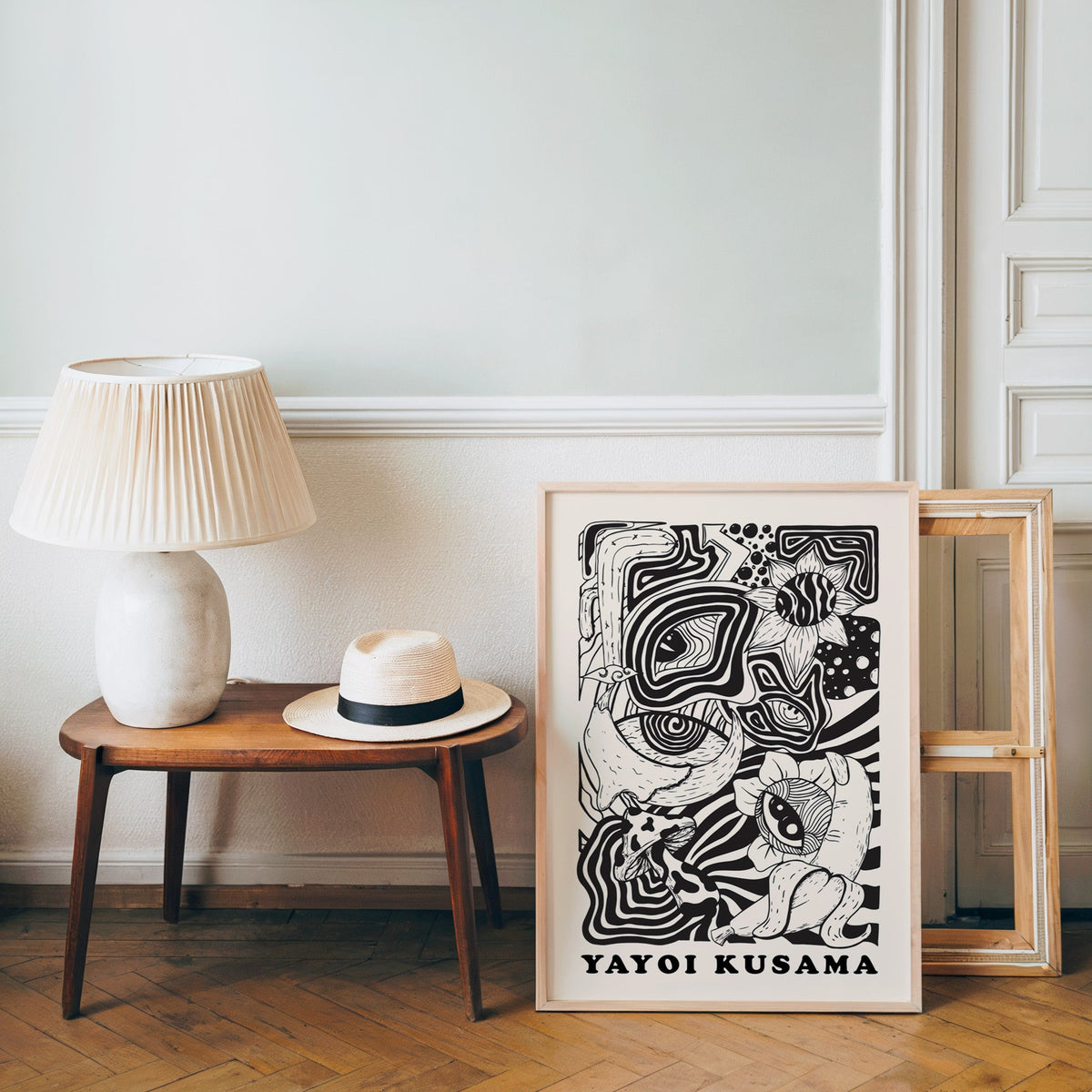 Yayoi Kusama inspired psychedelic eyes and mushroom print in an oak frame over a bench with a panama hat