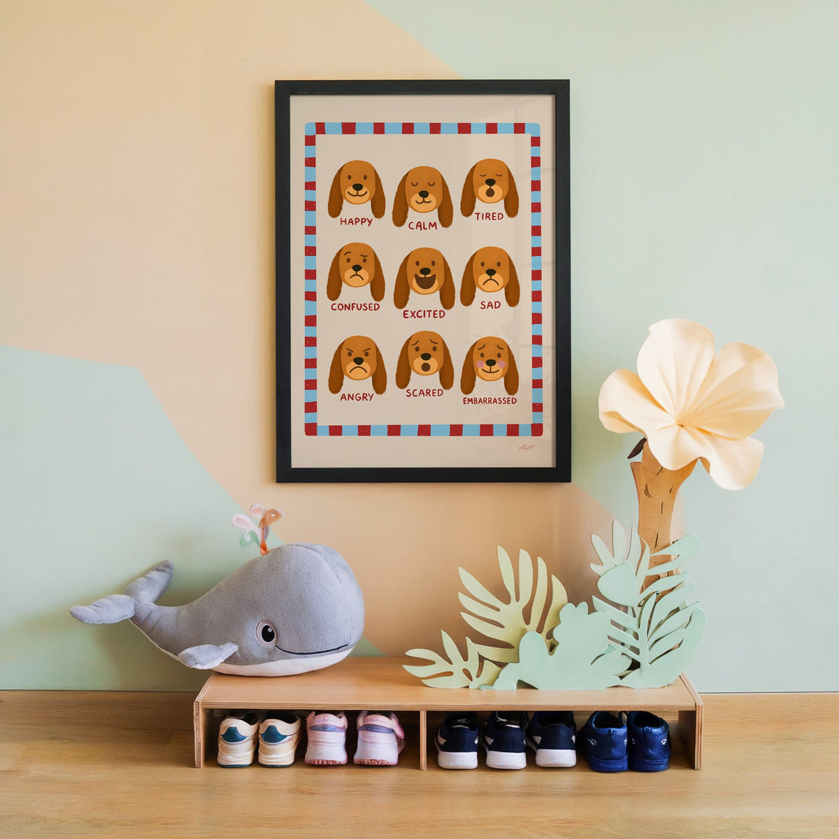 Puppy feelings chart nursery print in a black frame on a mint and peach wall above a whale plush