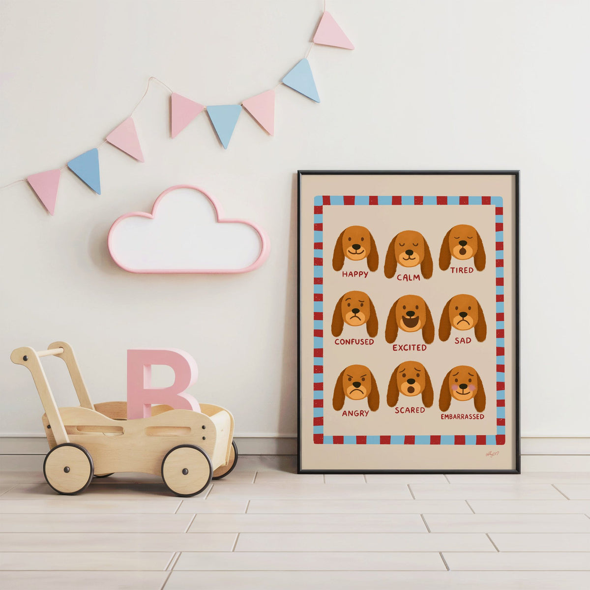 Puppy feelings chart nursery print in a black frame under pastel bunting by a wooden baby walker