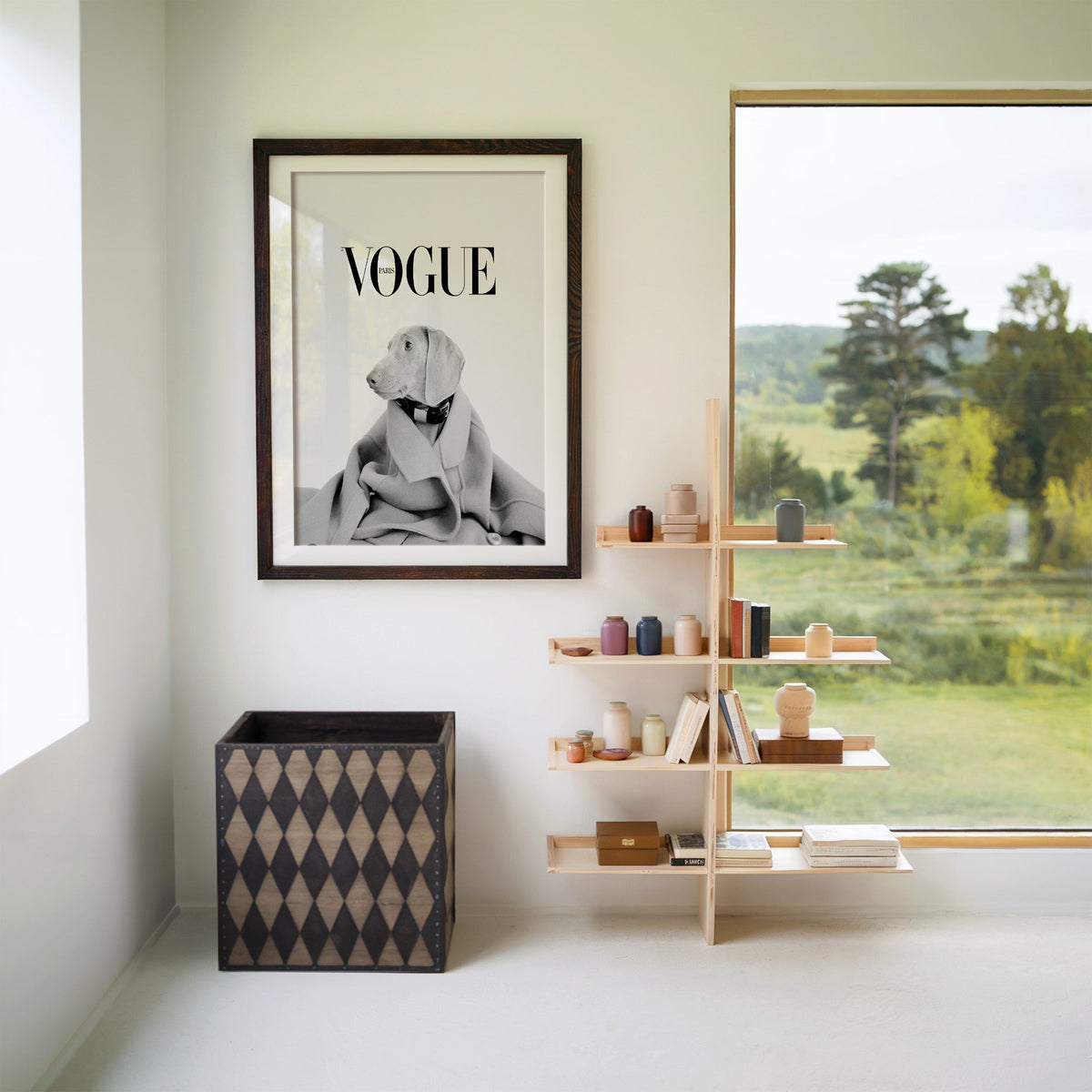 Puppy in oversized wool coat magazine cover print in a walnut frame with a white mat beside wooden shelves and a garden window