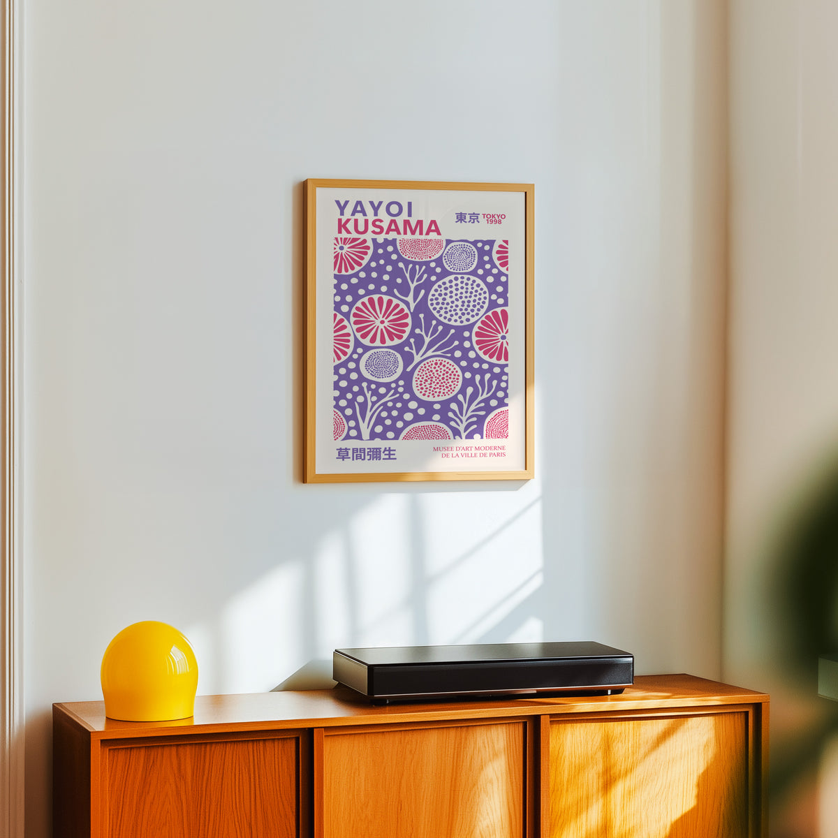 Yayoi Kusama inspired purple and pink floral dot print above a sideboard with a yellow lamp