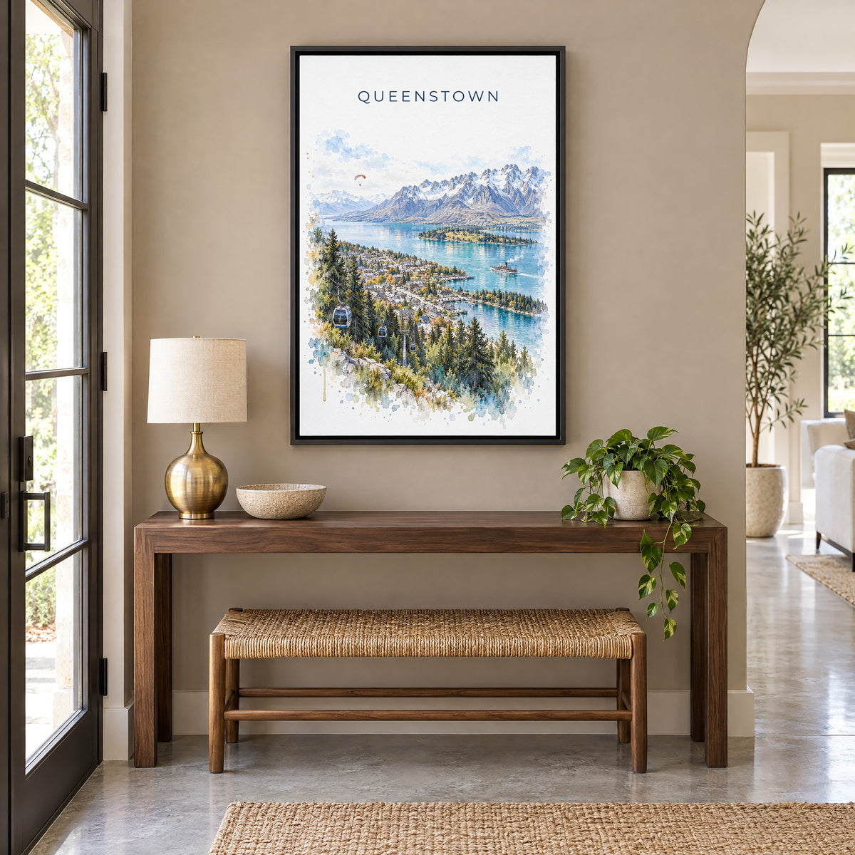 Queenstown watercolor print as a black floater canvas above a walnut console and woven bench in an entryway