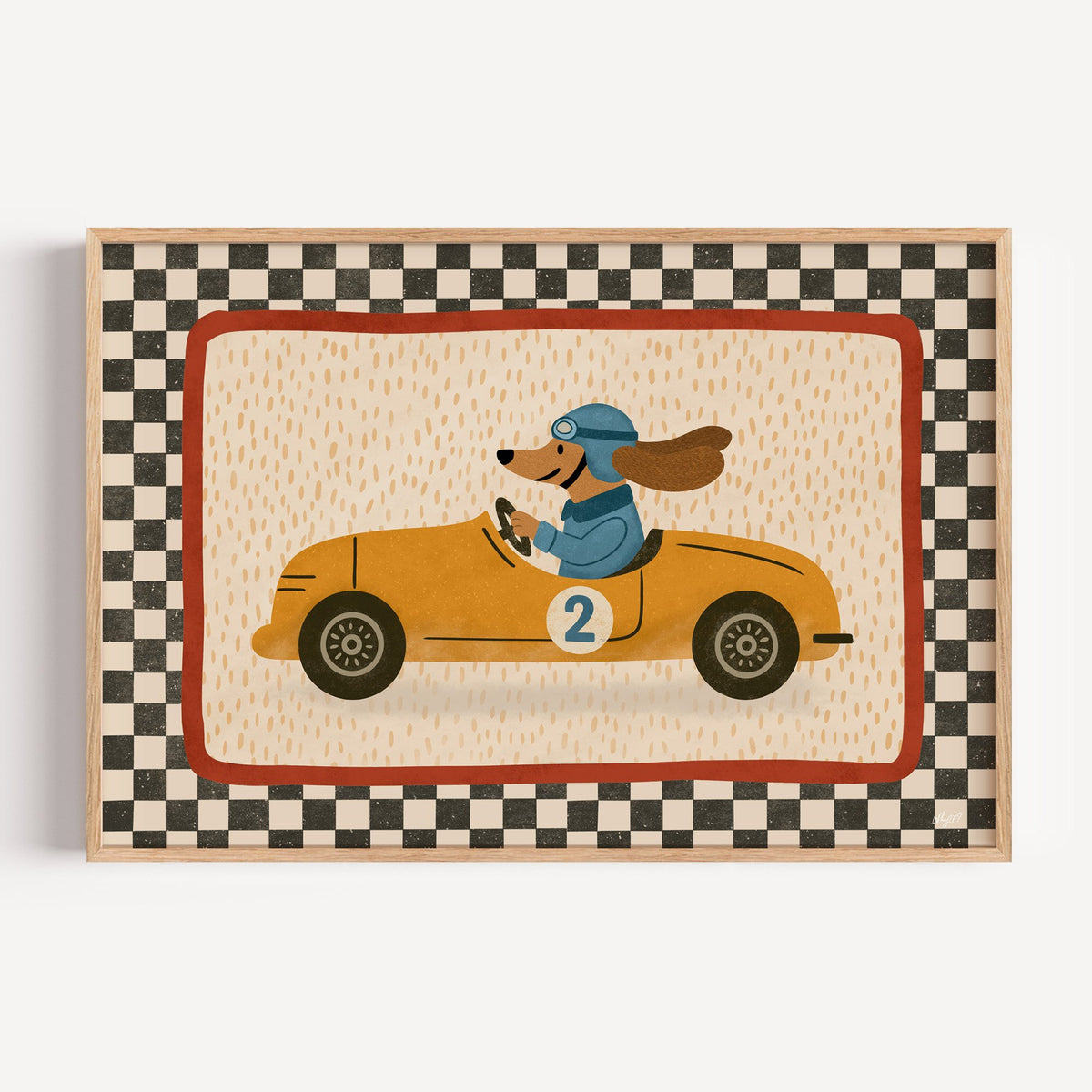 Dog driving yellow race car nursery print in a light oak frame on a plain white wall