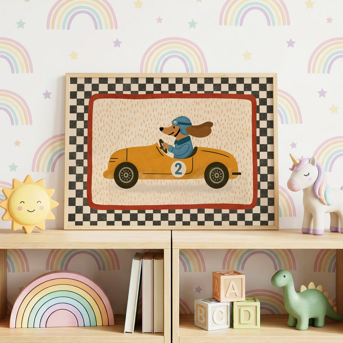 Dog driving yellow race car nursery print in an oak frame on a toy shelf against rainbow wallpaper