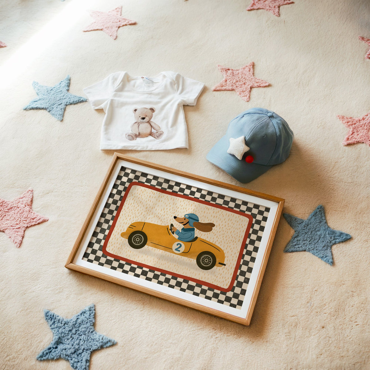Dog driving yellow race car nursery print in a matted oak frame on a star rug with a baby tee