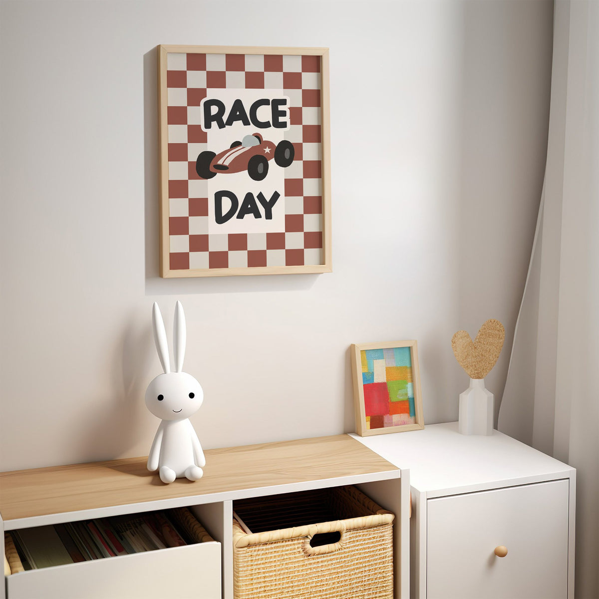 Race day red checkered nursery print in an oak frame above a kids cubby shelf with a woven basket and bunny lamp