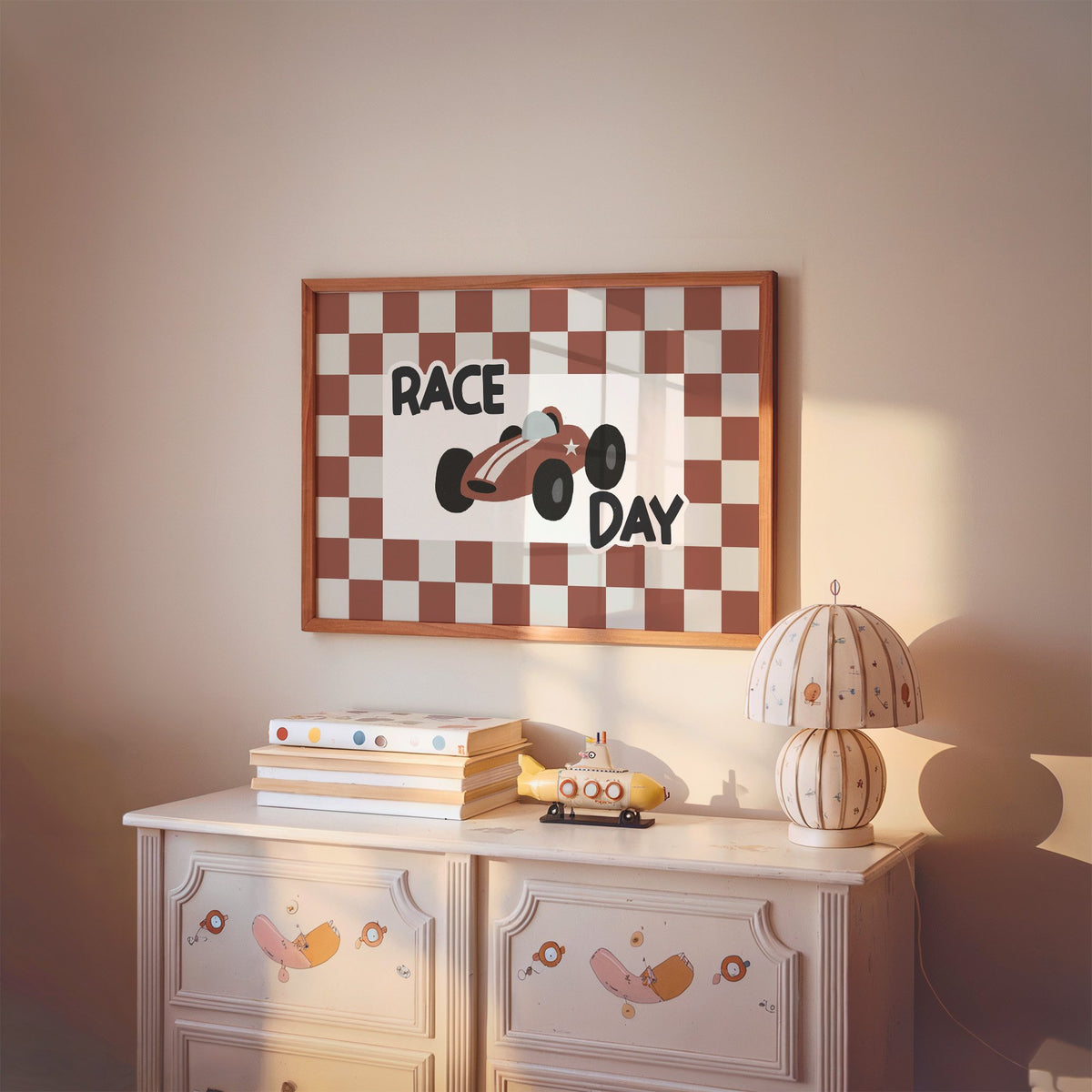 Landscape race day red checkered nursery print in a cherry wood frame above a painted dresser and lamp