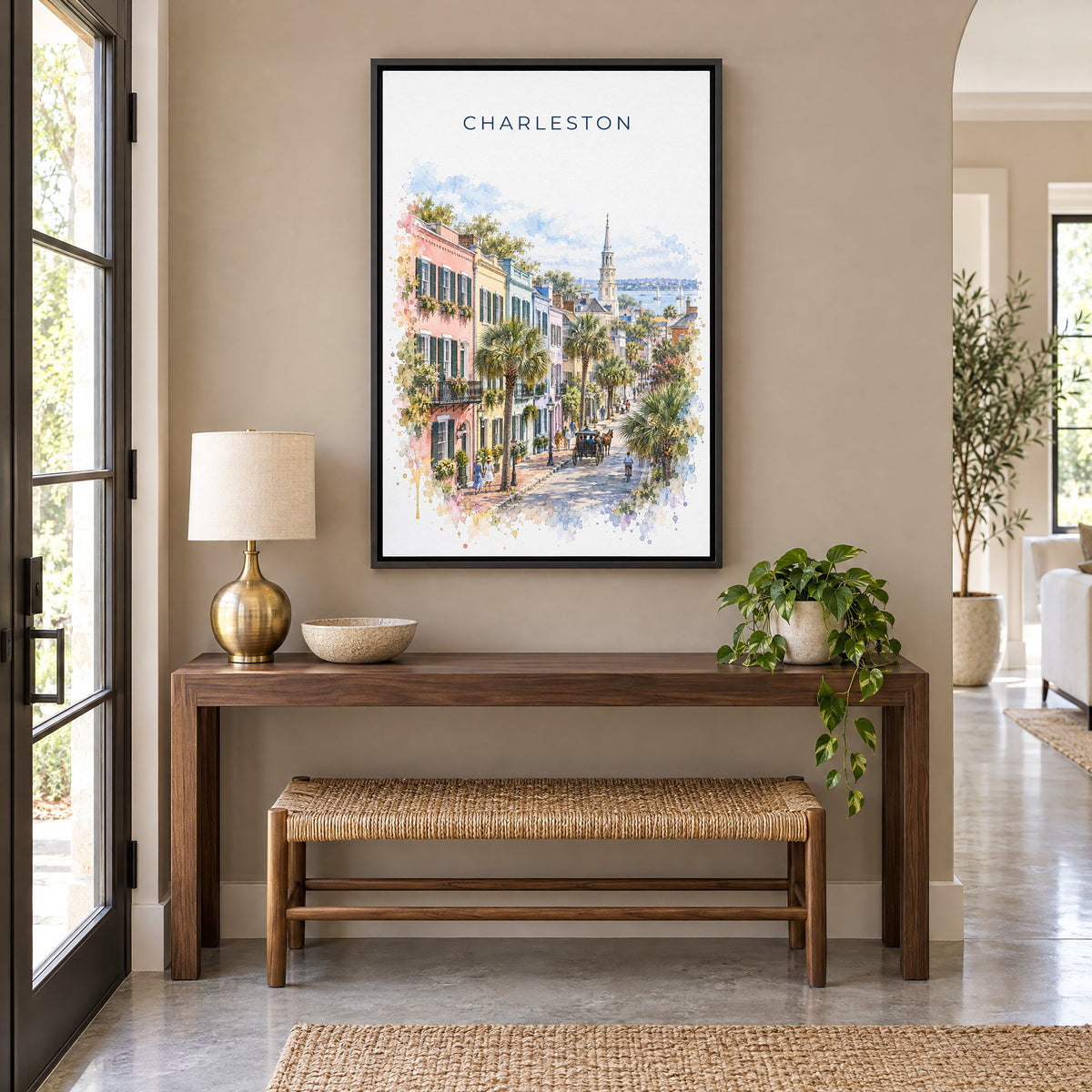 Rainbow Row Charleston watercolor print as a black floater canvas above a walnut console and woven bench in an entryway