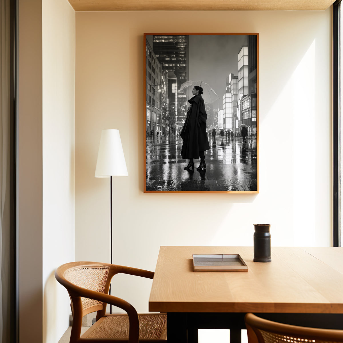 Woman with clear umbrella on rainy night street print in an oak frame above a dining table and cane chair