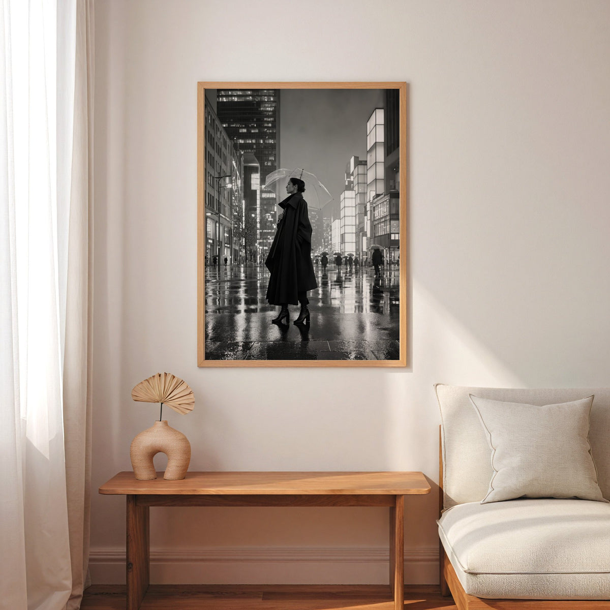 Woman with clear umbrella on rainy night street print in an oak frame above a narrow console with an arched vase